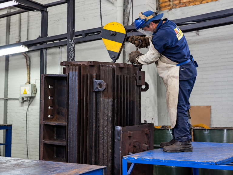 Operario ajustando polipasto en taller industrial